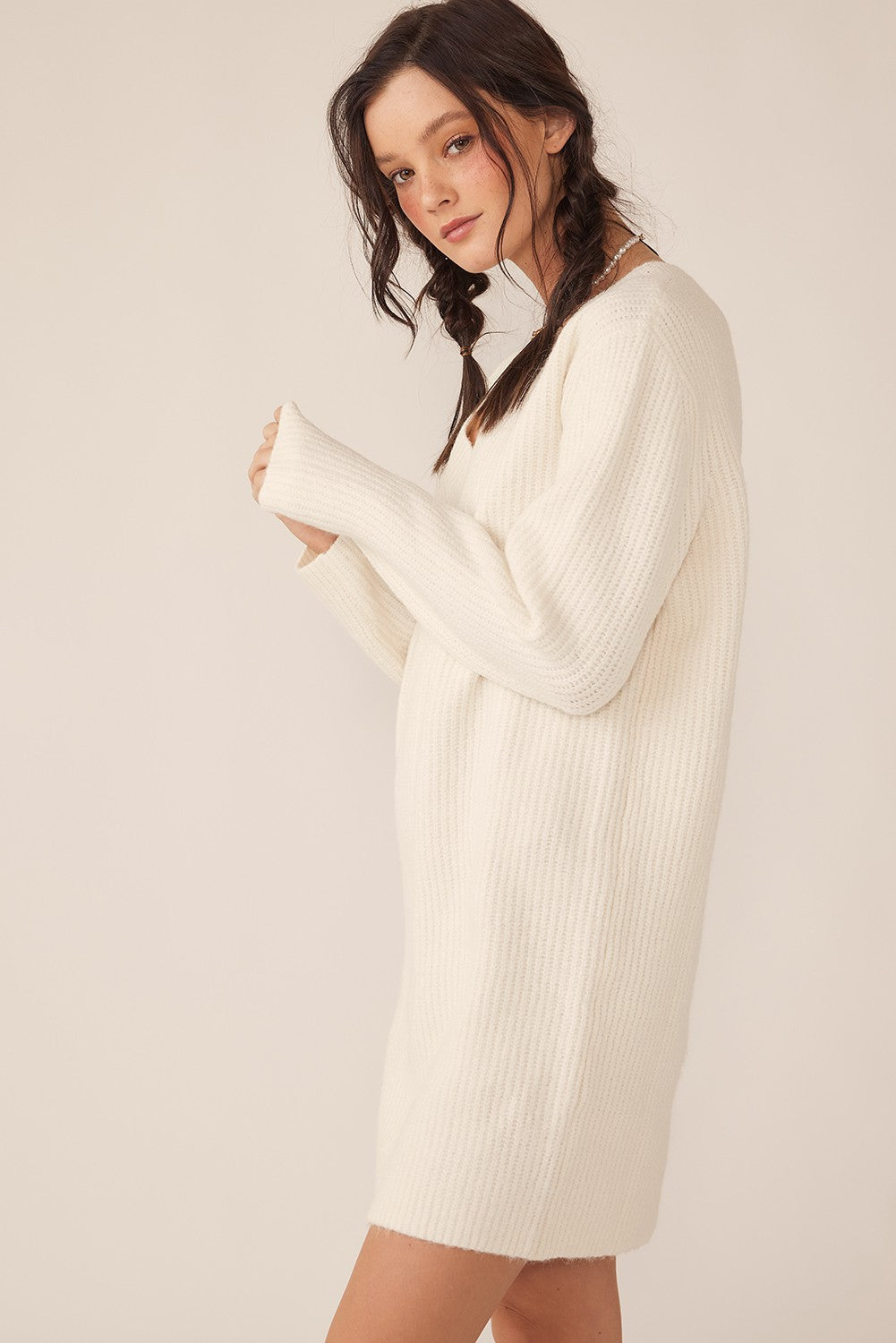 woman wearing a cozy white ribbed sweater dress with long sleeves and a relaxed fit