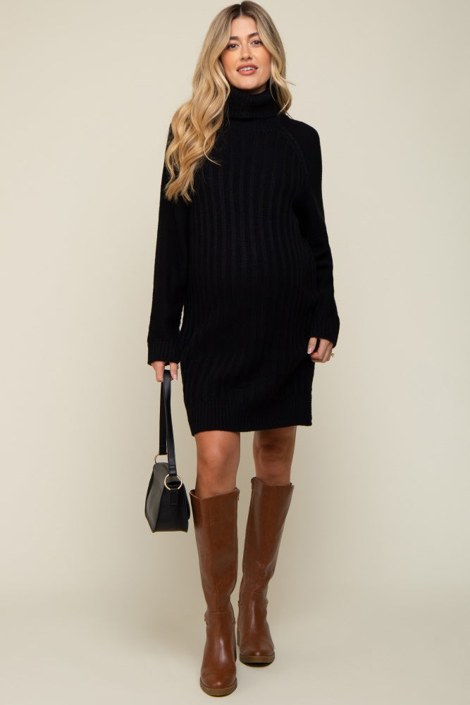 woman wearing a black ribbed maternity sweater dress with a turtleneck and knee-high brown boots, showcasing her baby bump