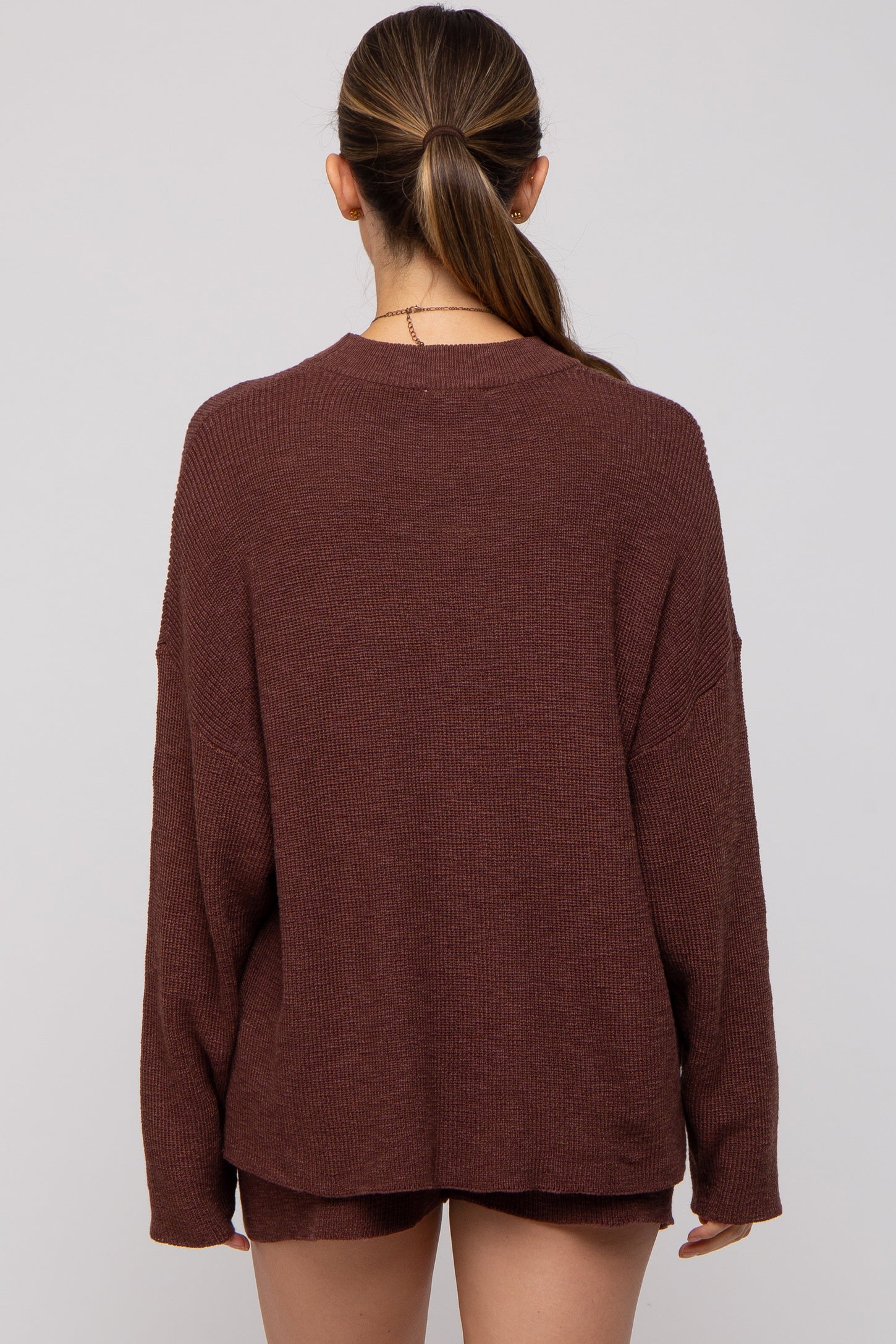 woman wearing a cozy rust long sleeve maternity sweater from the back