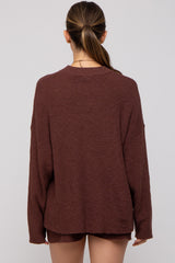woman wearing a cozy rust long sleeve maternity sweater from the back