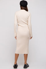 woman wearing a beige long sleeve ribbed maternity dress, showing a fitted silhouette from the back
