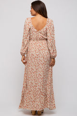 woman wearing a floral print maxi dress with a v-back and puffed sleeves, maternity wear