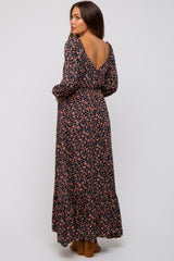 woman wearing a floral print maternity maxi dress with a v-back and long sleeves, showcasing her baby bump