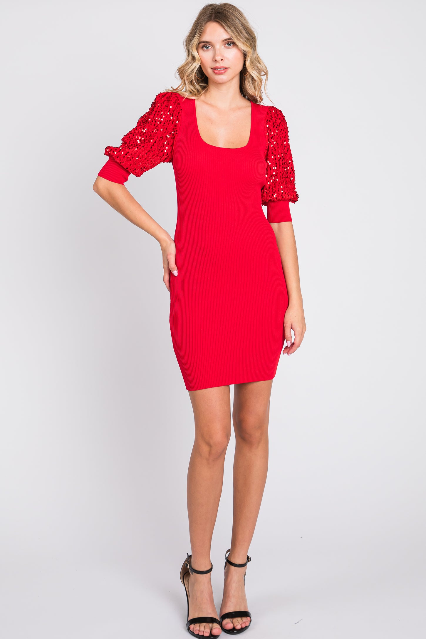 woman wearing a red ribbed mini dress with balloon sleeves adorned with sequins