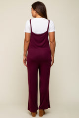 woman wearing a burgundy maternity jumpsuit with wide legs, shown from the back