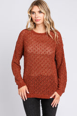 woman wearing a rust-colored open knit sweater with long sleeves and a relaxed fit