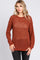 woman wearing a rust-colored open knit sweater with long sleeves and a relaxed fit