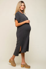 woman wearing a dark gray ribbed maternity dress with side slits and holding her baby bump