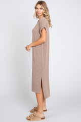 woman wearing a beige ribbed midi dress with short sleeves and side slits, standing sideways with a relaxed pose