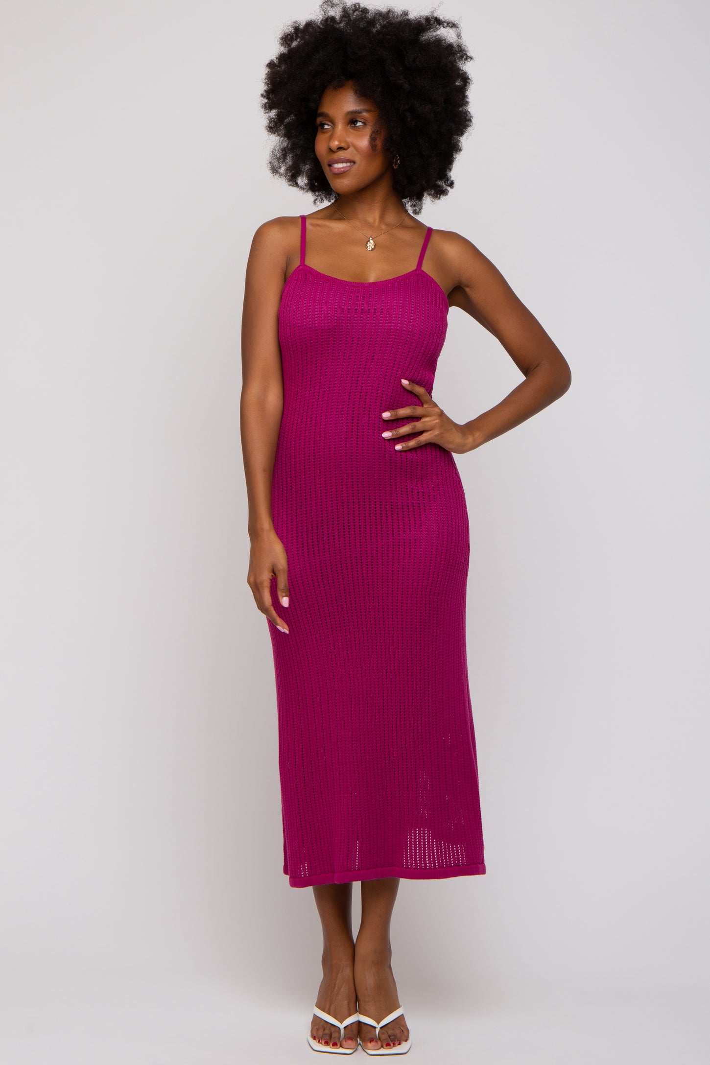 woman wearing a fuchsia ribbed midi dress with thin straps, standing and smiling
