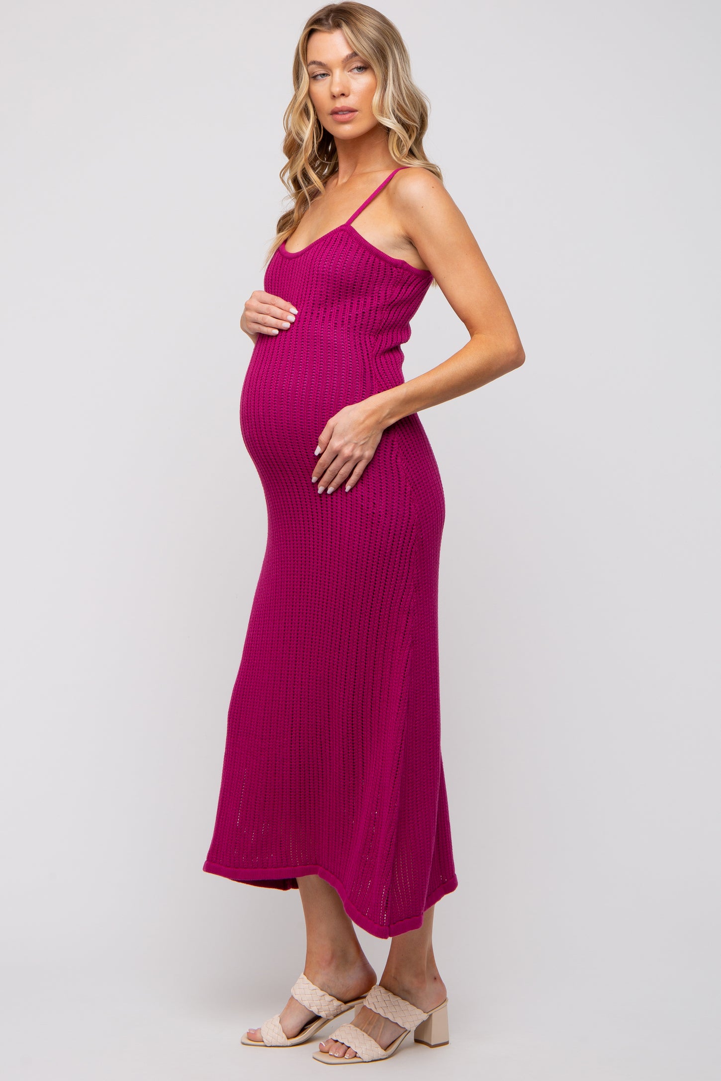 woman wearing a hot pink ribbed maternity dress and holding her baby bump