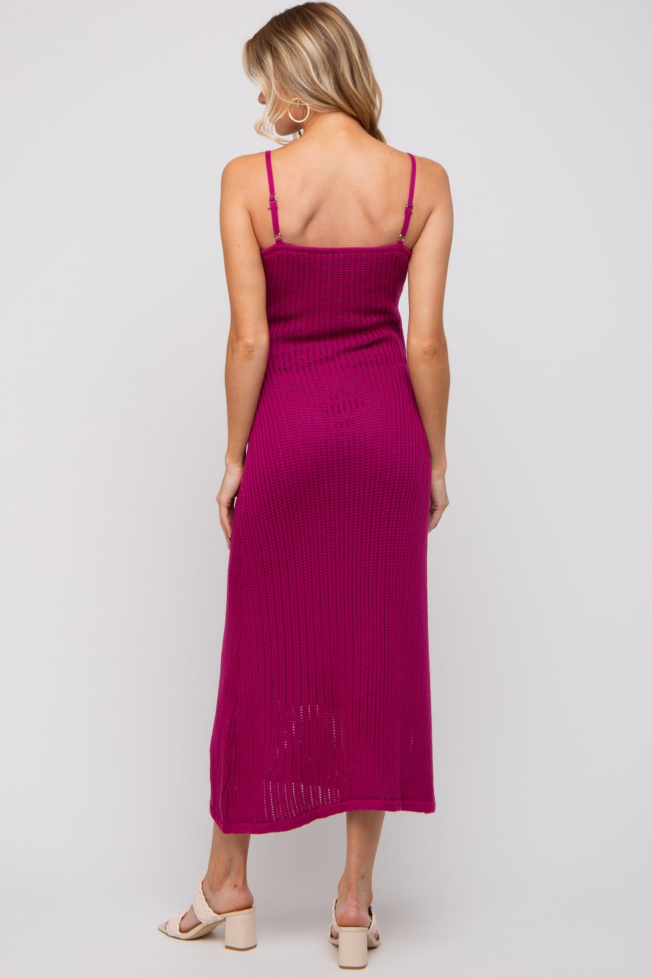 woman wearing a fuchsia ribbed knit maternity dress with adjustable straps and a mid-length cut