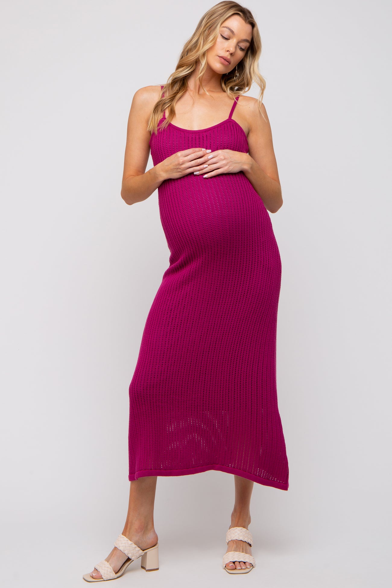 woman wearing a fuchsia ribbed maternity dress with adjustable straps and a visible baby bump