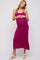 woman wearing a fuchsia ribbed maternity dress with adjustable straps and a visible baby bump