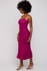 woman wearing a fuchsia ribbed midi dress with thin straps and a fitted silhouette