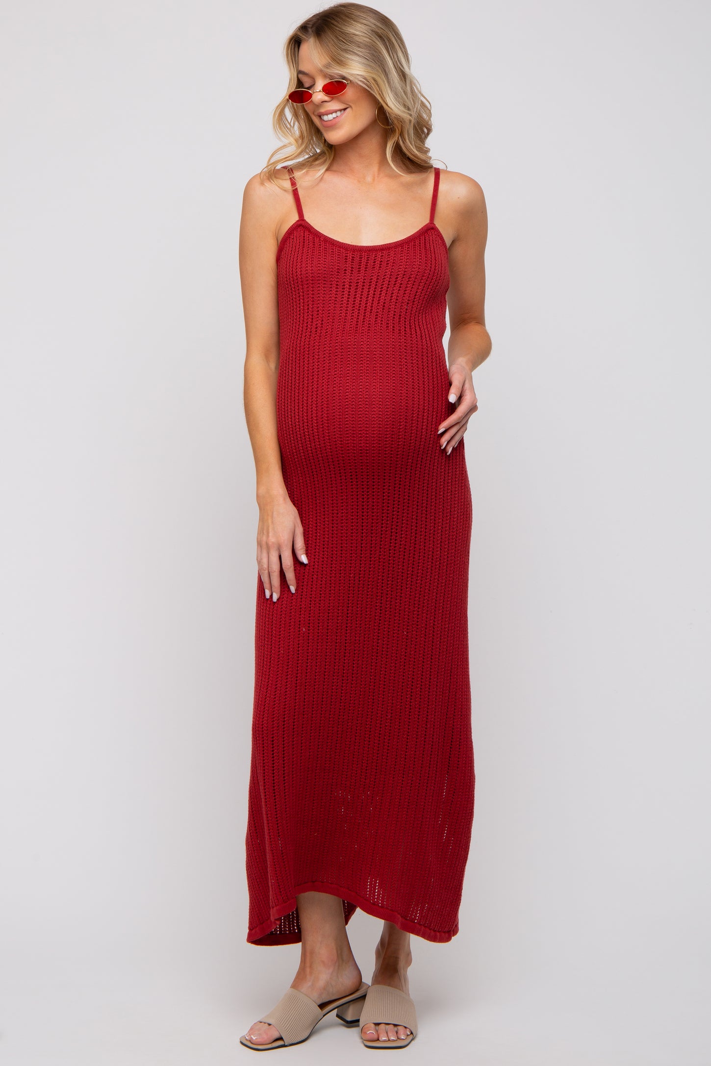 woman wearing a red ribbed maternity maxi dress with adjustable straps and a visible baby bump