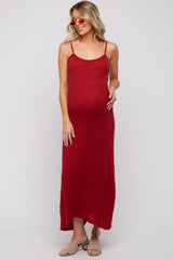 woman wearing a red ribbed maternity maxi dress with adjustable straps and a visible baby bump