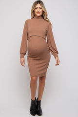 woman wearing a ribbed brown maternity dress with long sleeves and a fitted silhouette, showing her baby bump