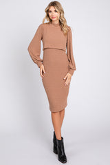 woman wearing a tan ribbed two-piece midi dress with balloon sleeves and a fitted skirt, paired with black ankle boots