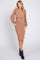 woman wearing a tan ribbed two-piece midi dress with balloon sleeves and a fitted skirt, paired with black ankle boots