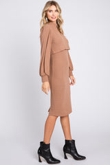 woman wearing a tan ribbed knit dress with long balloon sleeves and ankle boots