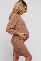 woman wearing a tan ribbed maternity dress with long sleeves and a side slit, touching her baby bump