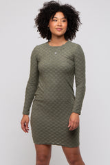 woman wearing a dark green long sleeve checkered mini dress with a fitted silhouette
