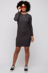 woman wearing a dark gray long sleeve textured dress paired with black and white sneakers and orange sunglasses