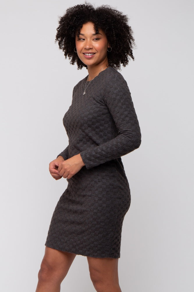 woman wearing a dark gray long sleeve dress with a textured pattern and a fitted silhouette