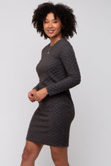 woman wearing a dark gray long sleeve dress with a textured pattern and a fitted silhouette