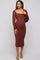 woman wearing a rust ribbed long sleeve maternity dress with cutouts and a visible baby bump, holding a black bag