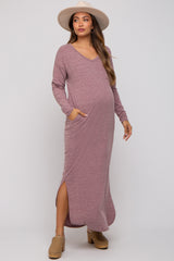 woman wearing a mauve long sleeve maternity dress with pockets and a side slit, showing her baby bump, paired with a wide-brim hat