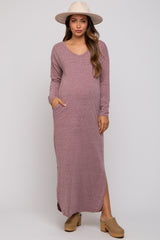 woman wearing a mauve long sleeve maternity dress with pockets and side slits, highlighting her baby bump