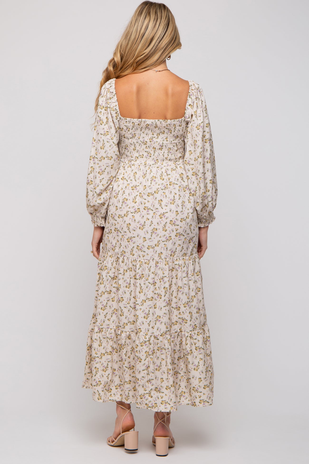 woman wearing a floral maternity maxi dress with long sleeves and a square neckline, showing a modest back design