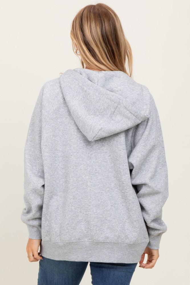 woman wearing a gray oversized hoodie, back view, with a hood and kangaroo pocket, styled with blue jeans