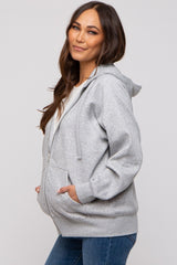 woman wearing a gray zip-up maternity hoodie with a front pocket and a visible baby bump