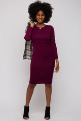 woman wearing a burgundy long sleeve bodycon dress and holding a black and white checkered scarf