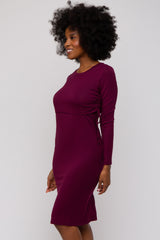 woman wearing a burgundy long sleeve dress with side ruching details