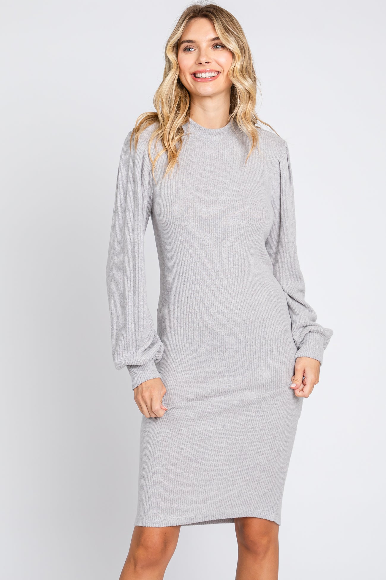 woman wearing a gray ribbed long sleeve dress with puffed sleeves and a fitted silhouette