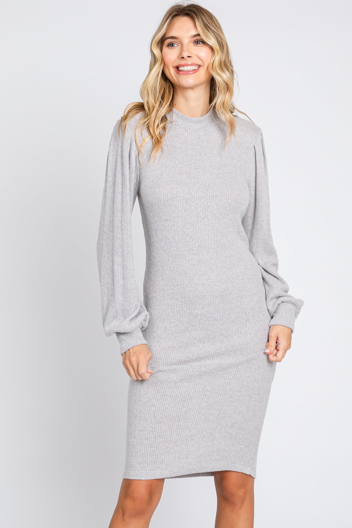 woman wearing a gray ribbed long sleeve dress with puffed sleeves and a fitted silhouette