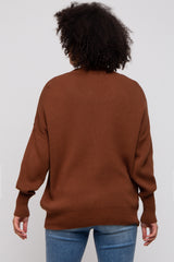 woman wearing a brown oversized sweater with a ribbed texture and a relaxed fit, viewed from the back
