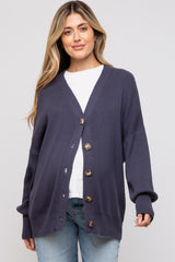 woman wearing a navy blue maternity cardigan with buttons and a v-neck, styled over a white t-shirt and jeans