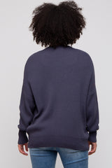 woman wearing a dark blue oversized sweater with a loose fit and long sleeves, seen from the back