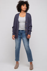 woman wearing a grey tank top, navy cardigan, and light blue jeans with beige mules