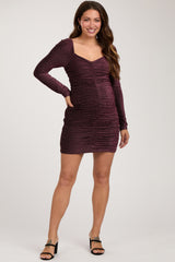 woman wearing a burgundy long sleeve ruched maternity dress with a v-neckline and visible baby bump