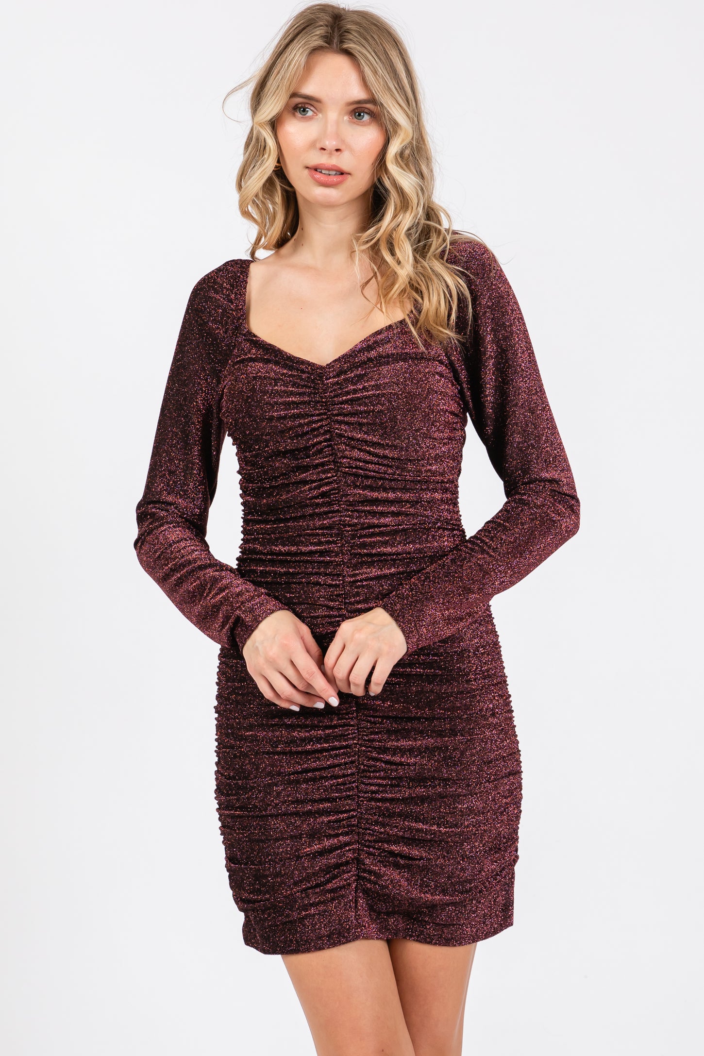 woman wearing a burgundy long sleeve ruched bodycon dress with a sweetheart neckline
