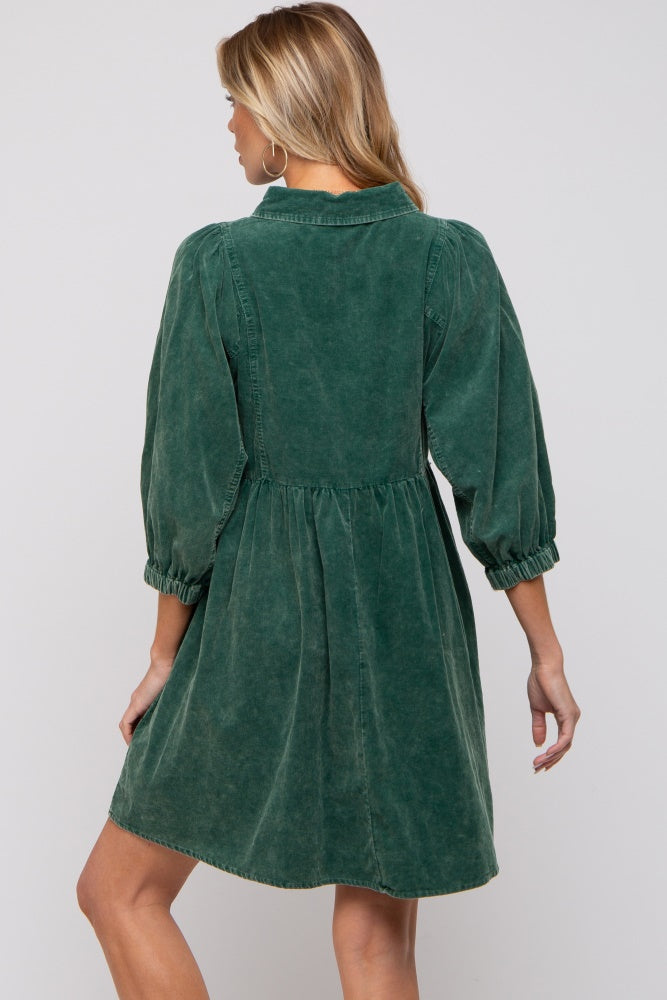 woman wearing a green maternity dress with puff sleeves and a fitted bodice, showing the back view