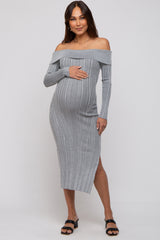 woman wearing a gray off-shoulder ribbed maternity dress with a side slit and holding her baby bump