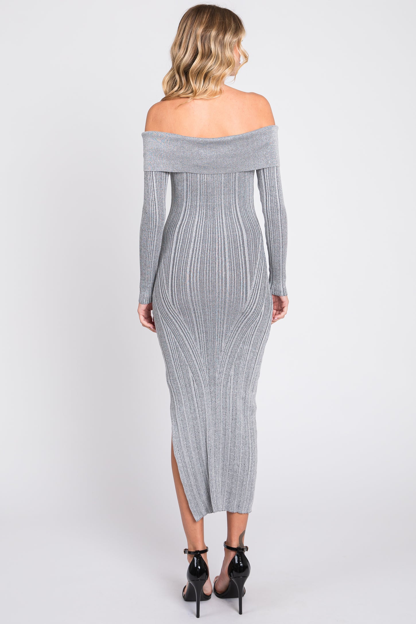 woman wearing a grey off-the-shoulder fitted maxi dress with ribbed detailing and side slit, viewed from the back