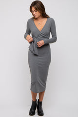 woman wearing a gray long sleeve wrap dress with a tie detail at the waist and a fitted midi length